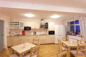 a kitchen and dining room with two tables and a refrigerator at Hostel Pomor in Barentsburg