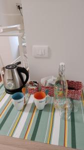einen Tisch mit drei Schüsseln und einer Flasche darauf. in der Unterkunft Bed and breakfast Puer Apuliae in Altamura