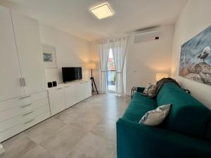 a living room with a green couch and a tv at Casa del Groto in Grado