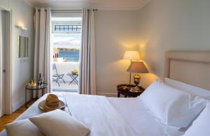 a bedroom with a bed with a view of the ocean at Poseidonion Grand Hotel in Spetses