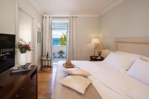 a bedroom with a large white bed and a window at Poseidonion Grand Hotel in Spetses