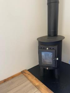 a black stove with a tv in a room at Henny Riverside Glamping in Sudbury