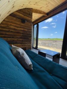 a bed in a room with a large window at Henny Riverside Glamping in Sudbury