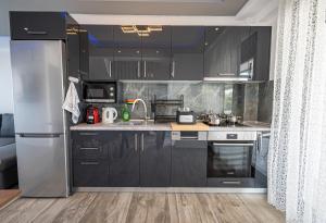 a kitchen with black cabinets and a stainless steel refrigerator at Chryssis Village by Travel Pro Services - Nea Potidaia Halkidiki in Nea Potidaea