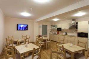 a dining room with wooden tables and a kitchen at Hostel Pomor in Barentsburg