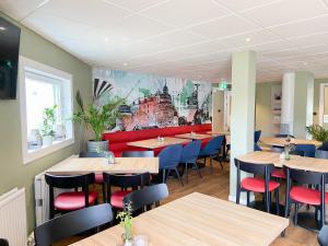a restaurant with wooden tables and blue chairs at Good Morning Örebro in Örebro