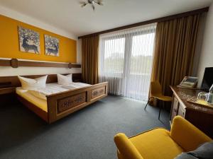 una camera d'albergo con letto e scrivania di Hotelgasthof Schmucker a Mossautal