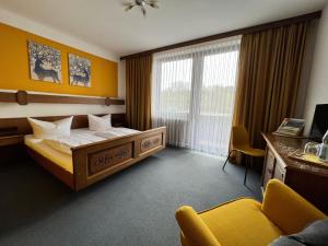 a hotel room with a bed and a desk at Hotelgasthof Schmucker in Mossautal