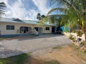 a house with a palm tree in front of it at Farida Apartments in Pointe Au Sel 