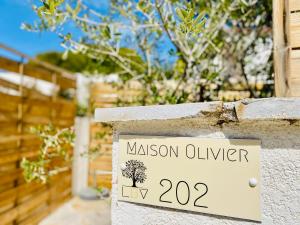 a sign on a stone wall with aason oliveralogy at Bella Vista Hôtel, Suites & Maisons in Porticcio