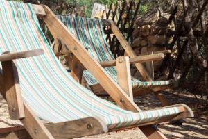 a wooden rocking chair sitting on the ground at Sa Guardia de Ferricci in Solanas