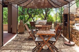 un patio con mesa y sillas bajo una sombrilla en Sa Guardia de Ferricci en Solanas
