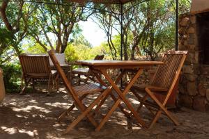 a wooden table and chairs sitting under a tent at Sa Guardia de Ferricci in Solanas