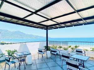 a patio with tables and chairs and a view of the ocean at Anstay Beach Da Nang in Danang