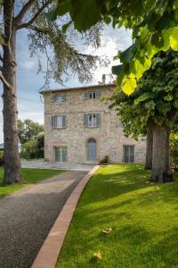 a stone house with a walkway in front of it at Relais Maria Cristina in Chianni