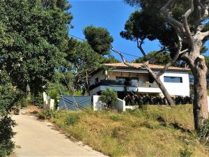 a house on a hill next to a dirt road at Studio Villa Le M in Six-Fours-les-Plages