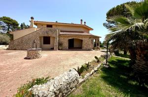 a house with a palm tree in front of it at Villa Rina in Avola