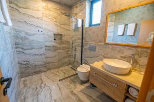 een badkamer met een wastafel, een toilet en een douche bij Belci City Residence in Fethiye