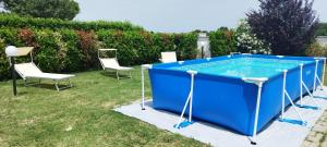 einen Pool im Hof mit zwei Stühlen und einem Tisch in der Unterkunft Villa Circuito Simoncelli in Misano Adriatico