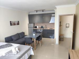 a kitchen and a living room with a couch and a table at Dolce Vita Residenza in Nesebar
