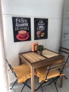 a table and chairs in a room with posters on the wall at Domus Alessia in Monserrato