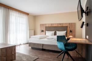 Schlafzimmer mit einem Bett, einem Schreibtisch und einem Stuhl in der Unterkunft Hotel & Restaurant Post in Laichingen