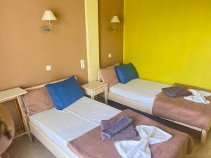 a room with two beds with towels on them at Villa Corfiota Moraitika Beach in Moraitika