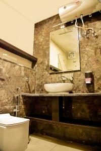 a bathroom with a sink and a toilet and a mirror at Clarks Inn Express, Jammu in Jammu