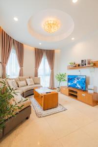 a living room with a couch and a tv at Sai Gon Pavillon Bà Huyện Thanh Quan Quận 3 in Ho Chi Minh City