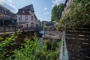 a bridge over a river in a city with buildings at La Maison de l'éclusier in Strasbourg
