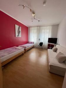 una camera con due letti e una parete rossa di In Fürth wie Zuhause a Fürth