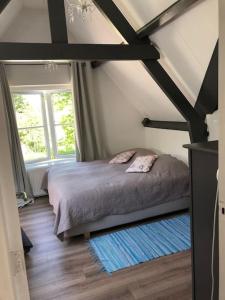 a bedroom with a bed in the middle of a room at Landhuis het Woud. max. 11 pers. with private pool in Bergen