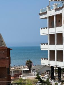 a building next to the ocean with a beach at Green Garden Villa in Durrës