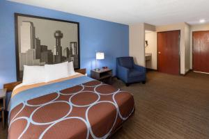 Habitación de hotel con cama y silla en Super 8 by Wyndham Garland/Rowlett/East Dallas area, en Garland