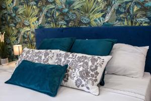 a bed with four pillows and a blue head board at Airport Fly House in Naples