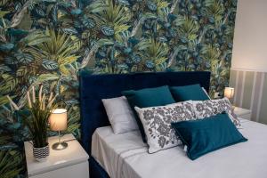 um quarto com uma cama com papel de parede azul e verde em Airport Fly House em Nápoles
