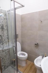 uma casa de banho com um WC, um chuveiro e um lavatório. em Airport Fly House em Nápoles