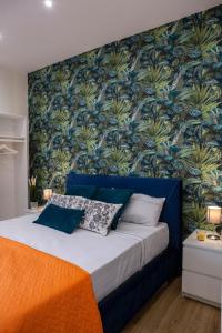 a bedroom with a blue bed with a tropical wallpaper at Airport Fly House in Naples
