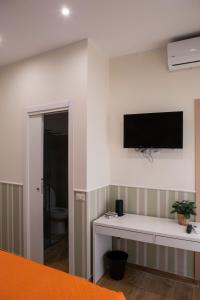 ein Wohnzimmer mit einem TV an der Wand in der Unterkunft Airport Fly House in Neapel