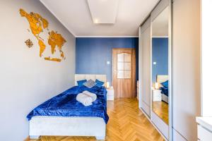 - une chambre avec un lit bleu et blanc et un miroir dans l'établissement Bosman Apartment Gdynia, à Gdynia