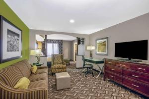 a living room with a couch and a flat screen tv at La Quinta by Wyndham Kearney in Kearney
