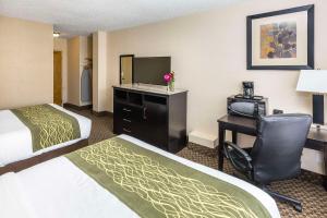 a hotel room with two beds and a desk with a computer at Comfort Inn & Suites in Edmonton