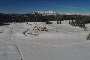 a ski resort in the snow with trees and mountains at Malga Millegrobbe Nordic Resort in Lavarone