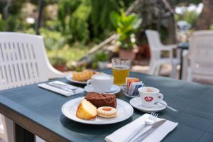 una mesa con platos de comida y tazas de café en Hotel La Fonte a 300m uscita A14 Pescara Nord, en Citta' Sant'Angelo