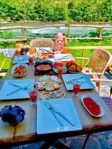 a wooden table with food and drinks on it at Seyridere süit bungalov in Çamlıhemşin