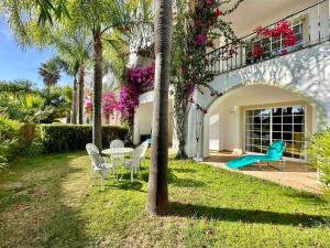 une maison avec une aire de jeux, une table et des chaises dans l'établissement Casa Buccaneer, 2 Bedroom Garden Apartment in Praia da Luz, à Luz