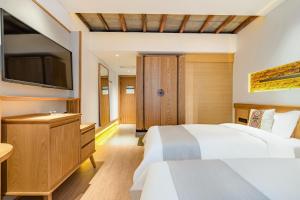 a bedroom with two beds and a flat screen tv at Yoba Boutique Hotel in Zhangjiajie