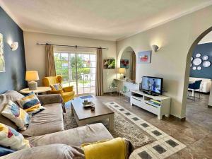 - un salon avec un canapé et une télévision dans l'établissement Casa Buccaneer, 2 Bedroom Garden Apartment in Praia da Luz, à Luz