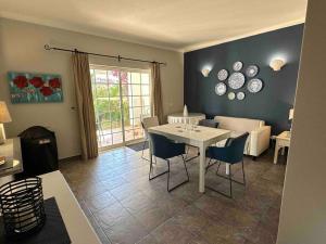 - un salon avec une table et des chaises blanches dans l'établissement Casa Buccaneer, 2 Bedroom Garden Apartment in Praia da Luz, à Luz