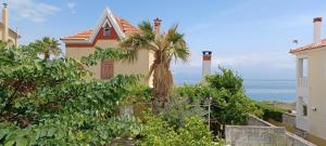 una casa con una palmera frente al océano en Garden Seaview Luxury Apartment, en Mytilini